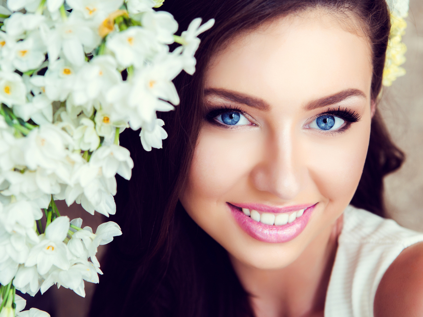 Красивая голубоглазая брюнетка с нежными цветами белой орхидеи