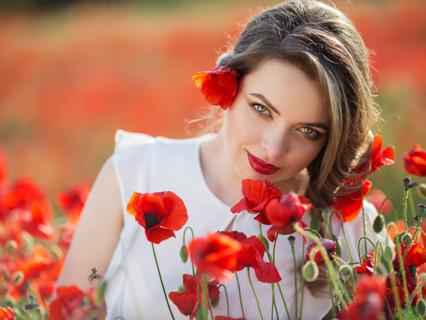 Красивая девушка с выразительным взглядом на поле с красными маками
