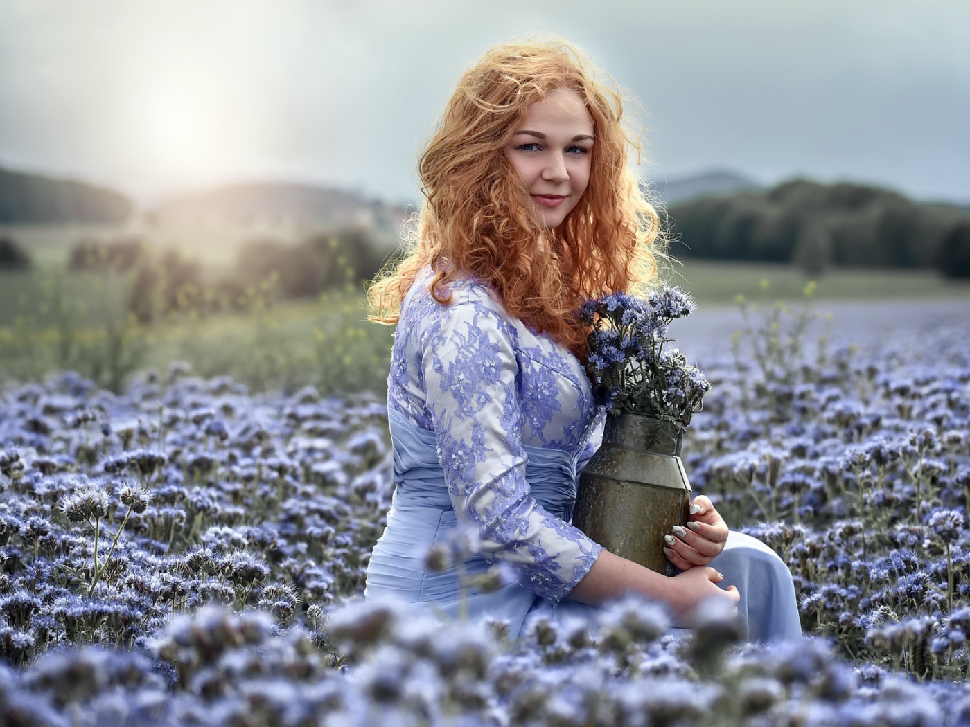 Красивая рыжеволосая девушка собирает цветы