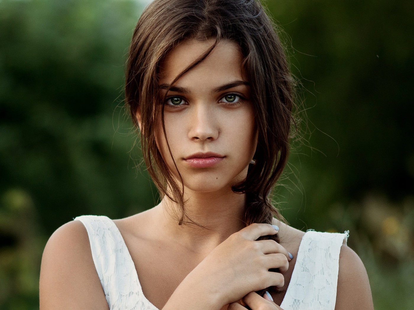 Красивая молодая зеленоглазая девушка с косой на голове