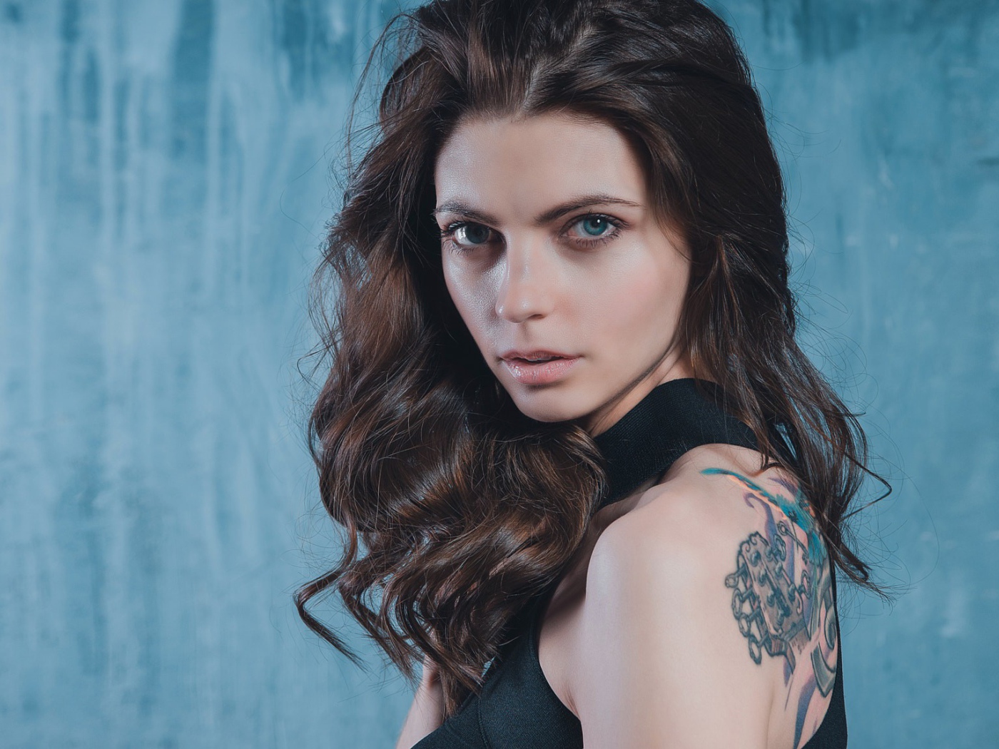 Голубоглазая девушка с татуировкой на спине 