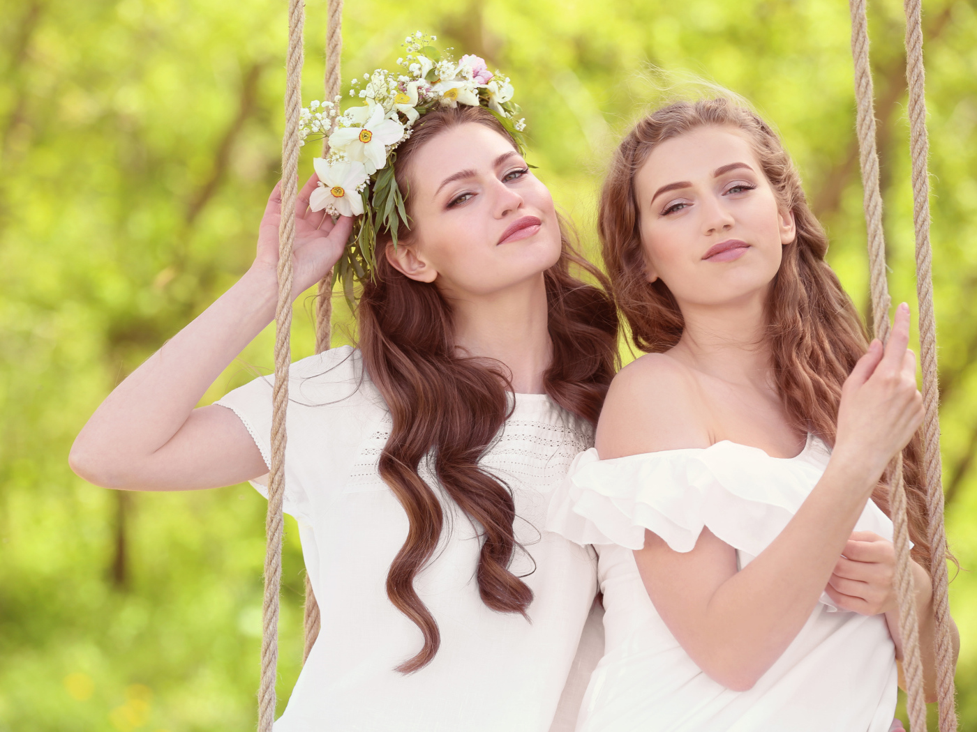 Две красивые длинноволосые девушки шатенки на качели
