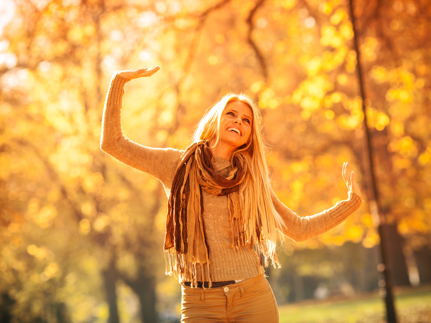 Молодая красивая девушка радуется теплому осеннему солнцу