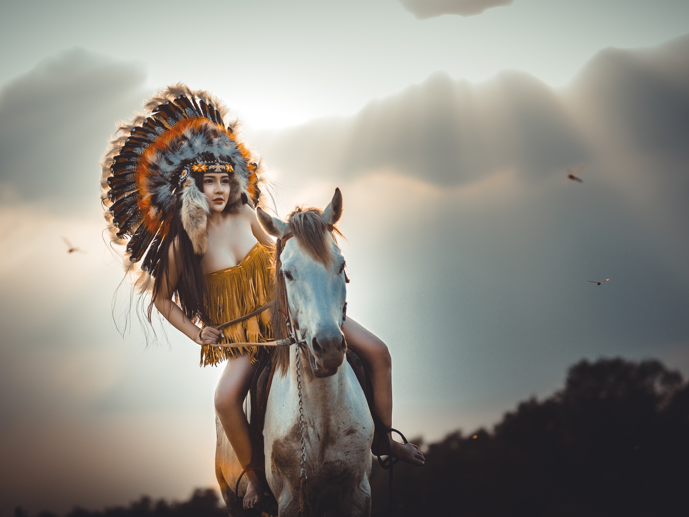 Молодая девушка в костюме индейца на коне