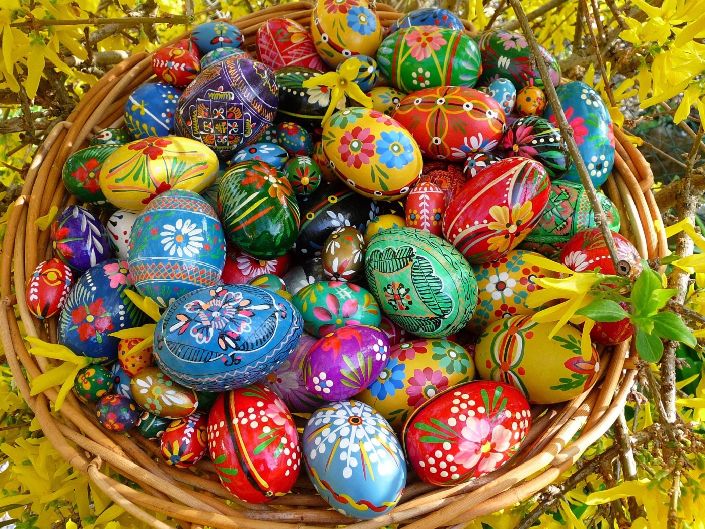 Яркие расписные пасхальные яйца в корзине 