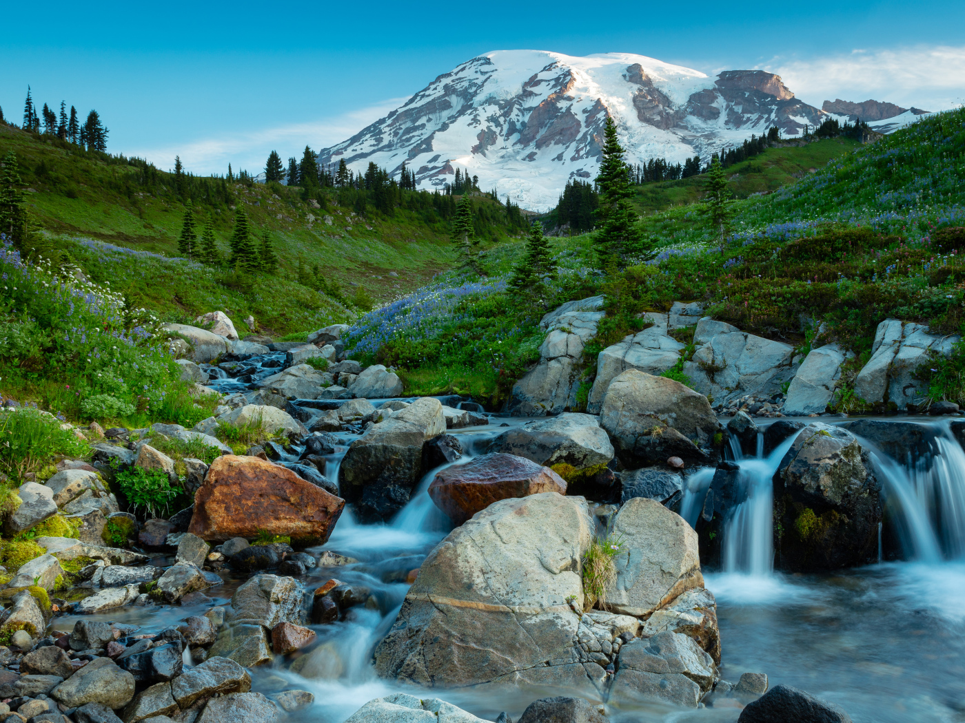 Живописный ручей течет по камням на фоне горы