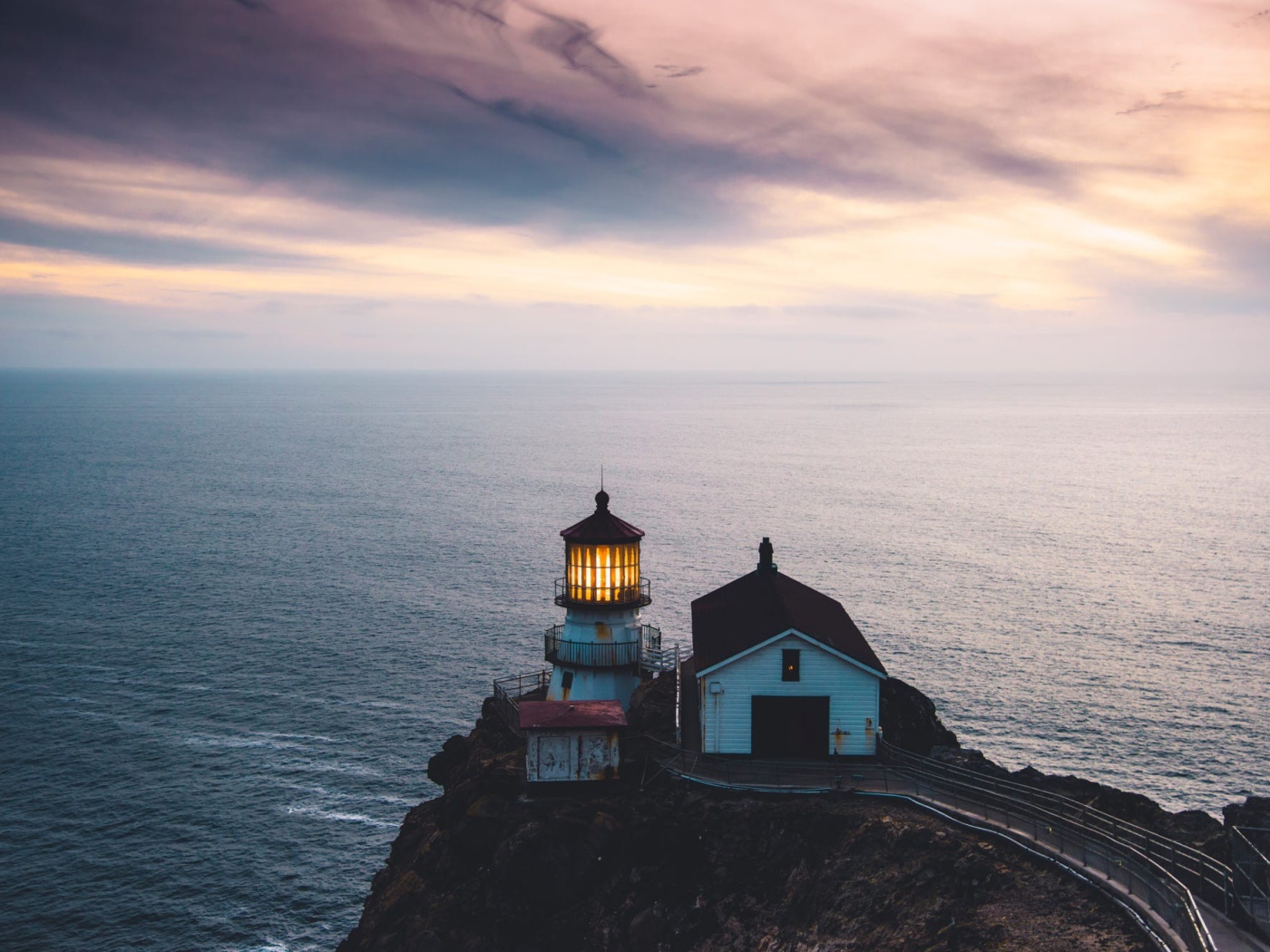 Маяк на скале на фоне горизонта океана 