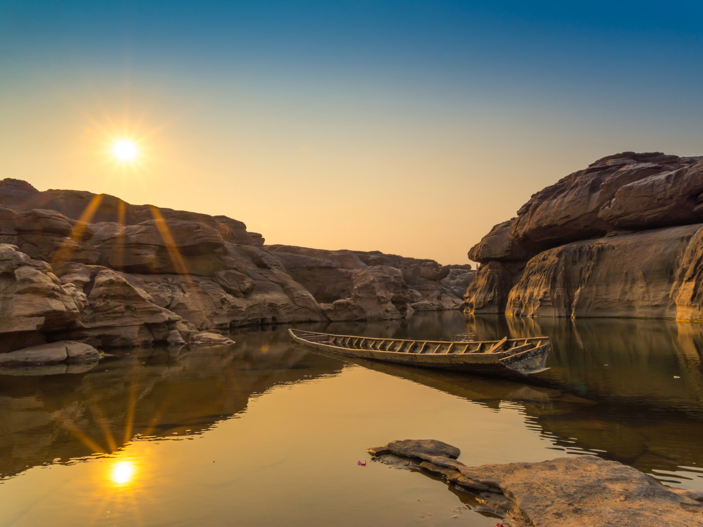 Лодна на озере между скал на рассвете