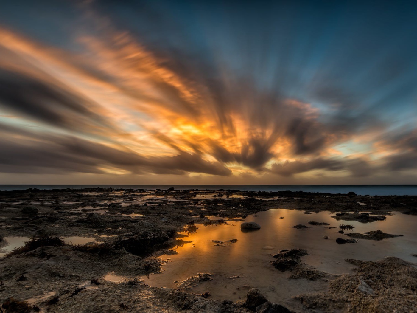 Закат солнца в облаках над водой 