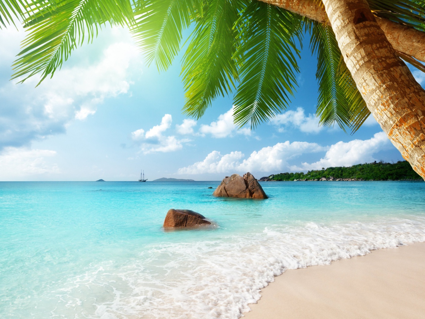 Голубая вода океана омывает белый песок на тропическом пляже