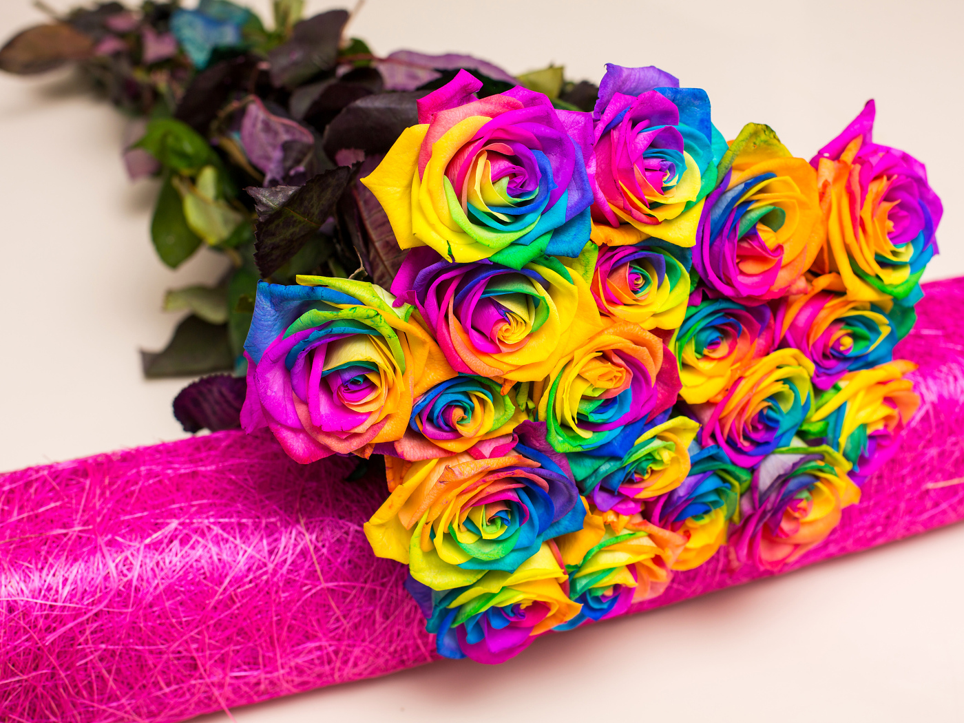 Букет разноцветных ярких роз на сером фоне