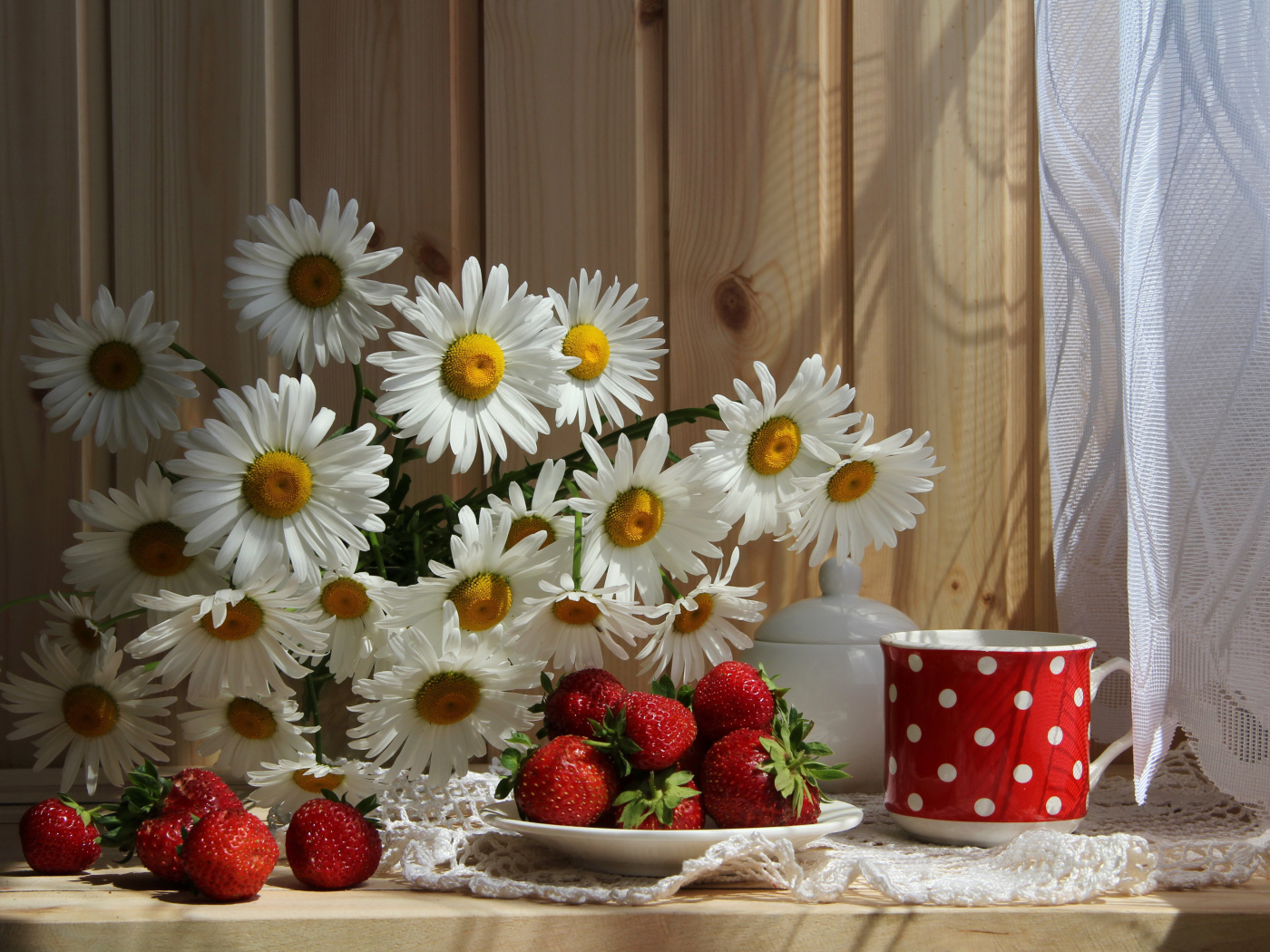 Букет белых ромашек на столе с клубникой