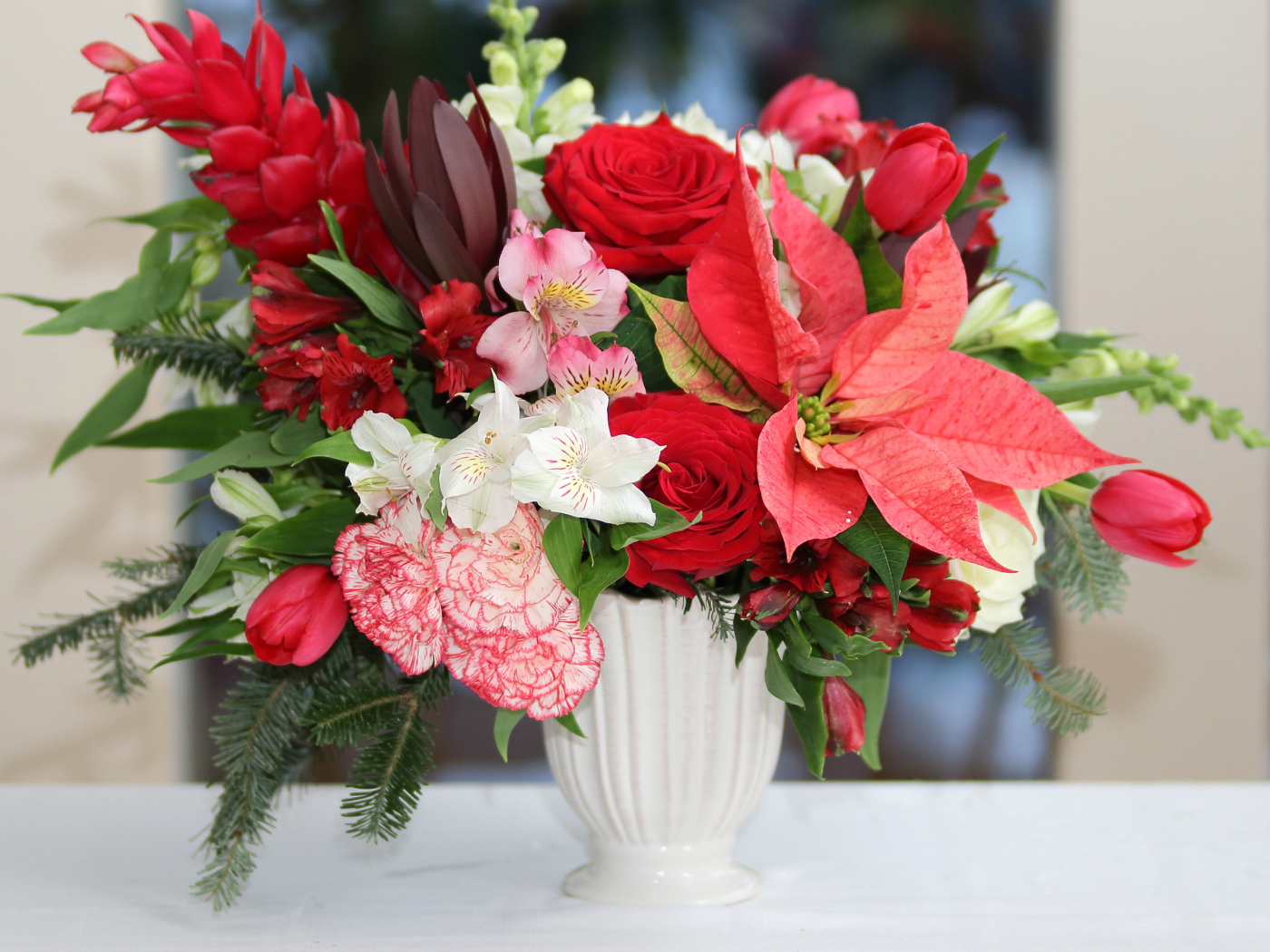 Розы, альстрёмерия, тюльпаны, гвоздики и молочай в красивом букете в белой вазе