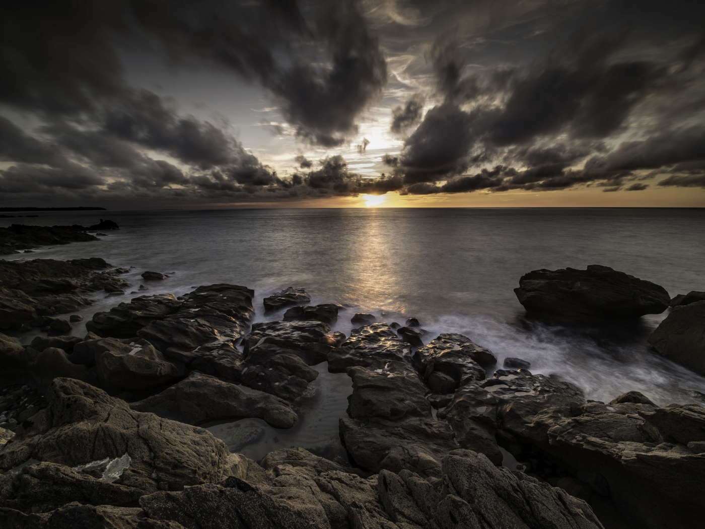 Низкие черные облака на закате в небе над океаном