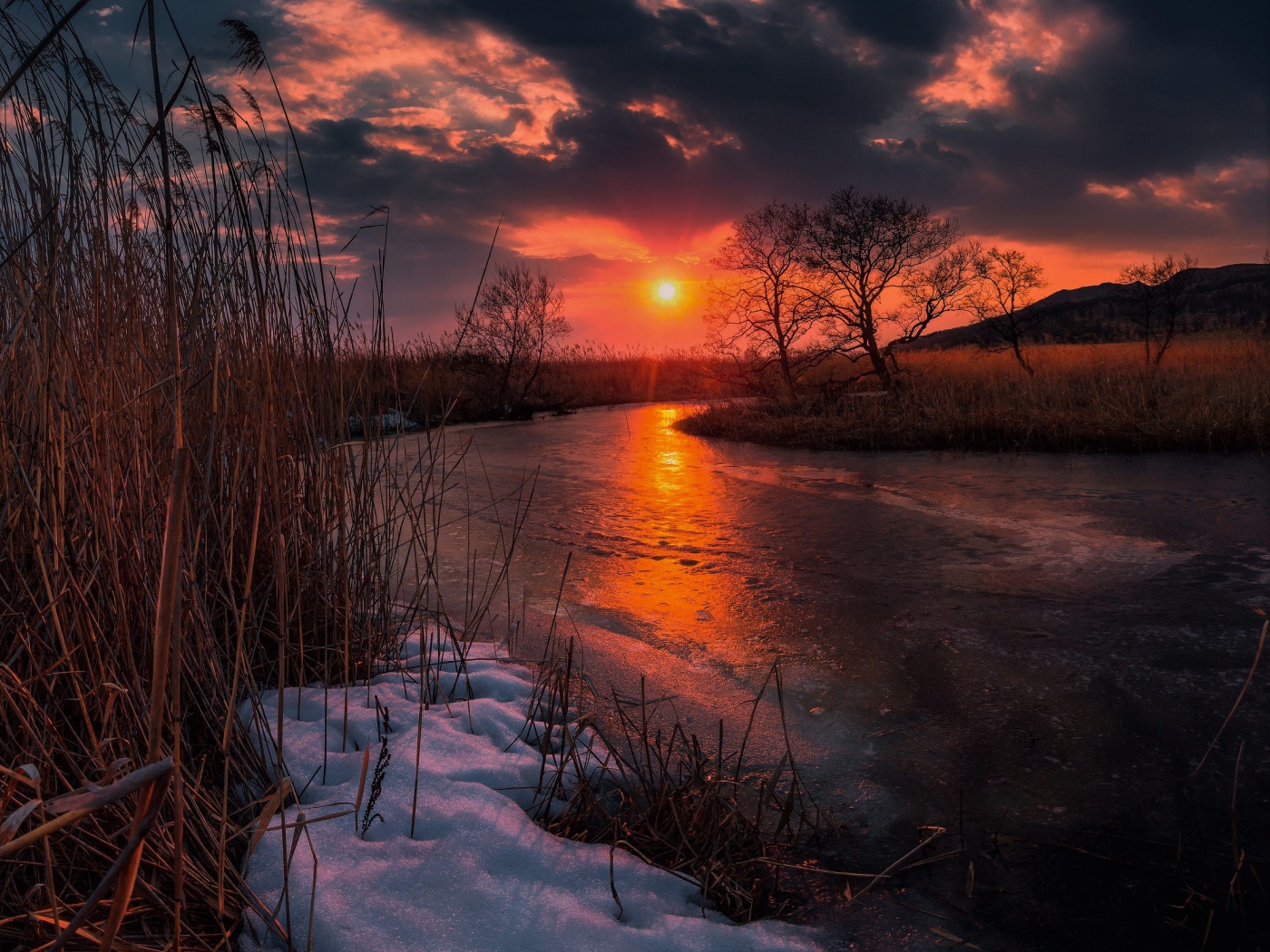 Закат солнца над покрытой льдом рекой