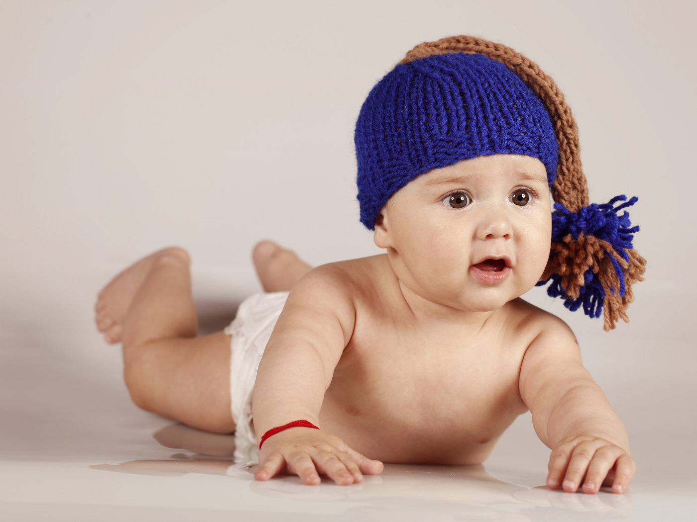 Грудной кареглазый ребенок в вязаной шерстяной шапке