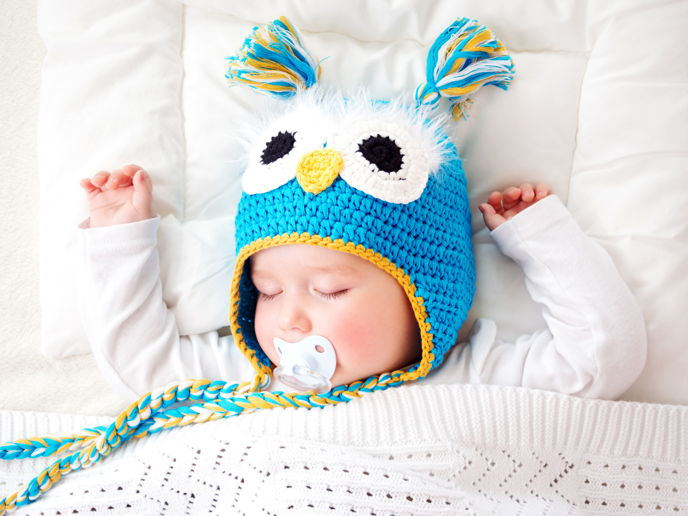 Спящий ребенок в забавной вязаной шапке