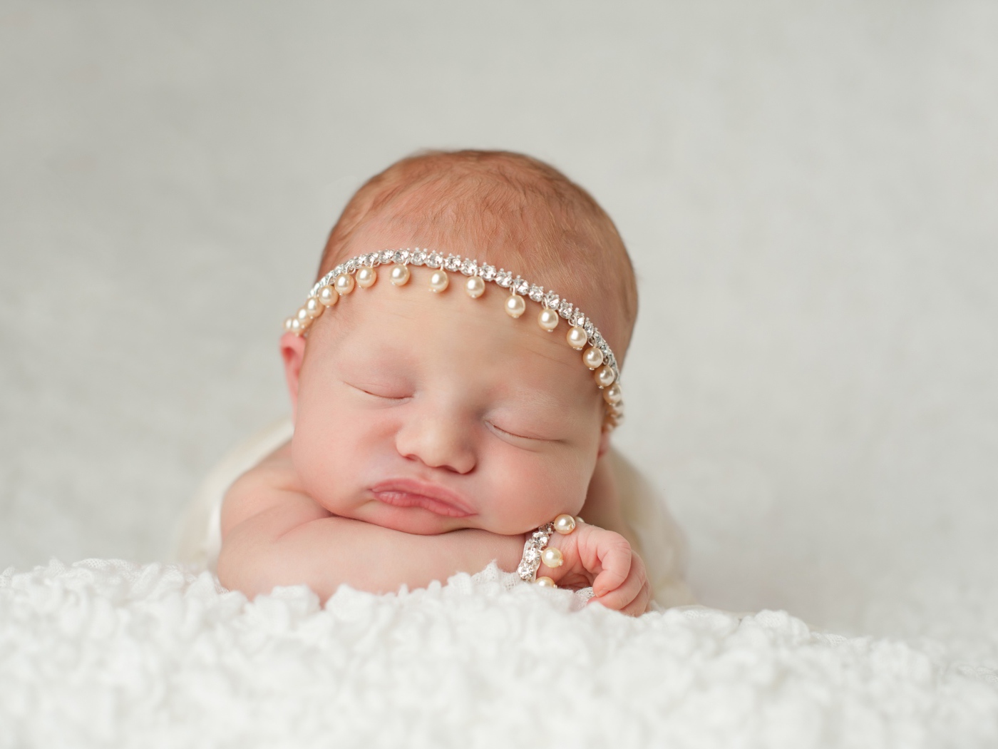 Маленький спящий грудной ребенок с красивым украшением на голове