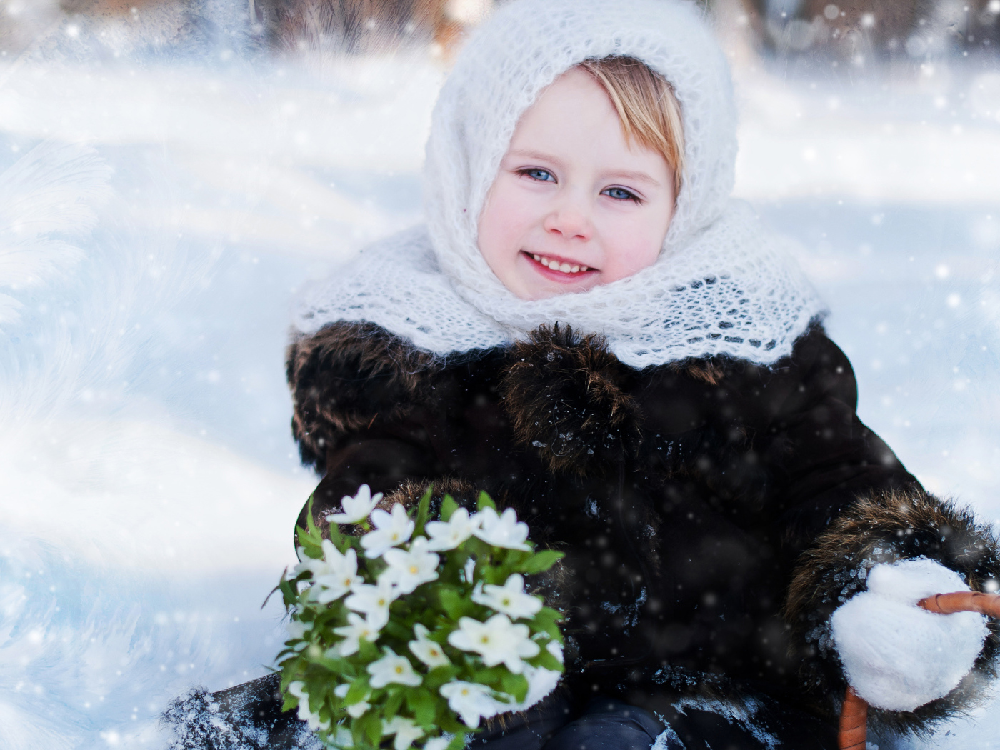 Маленькая голубоглазая девочка с букетом подснежников зимой