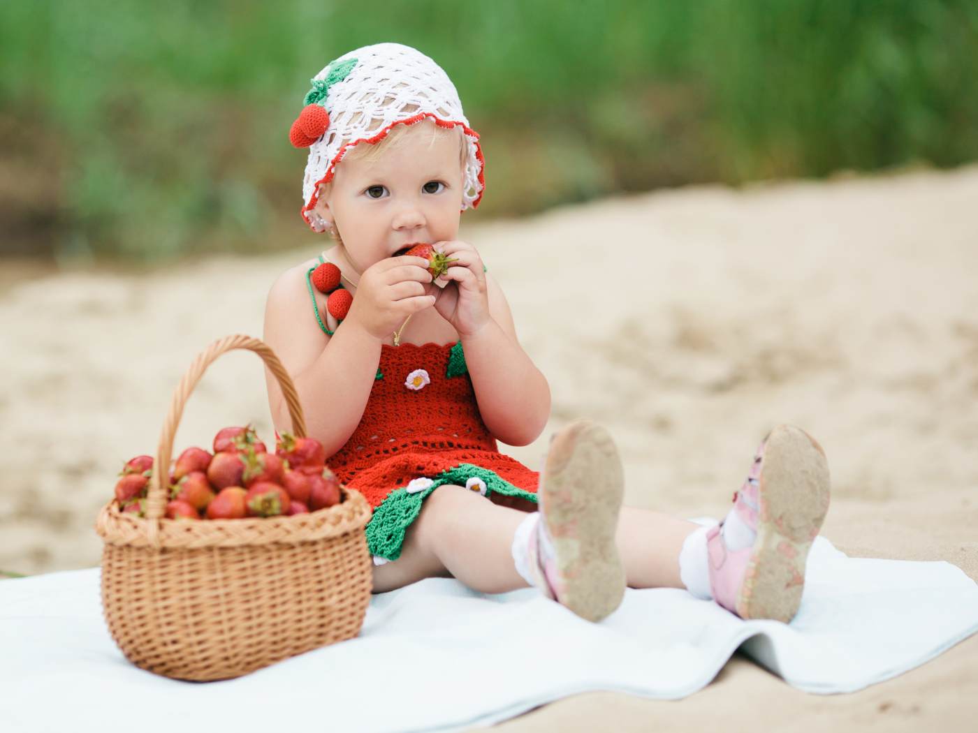 Маленькая девочка в большой корзиной клубники