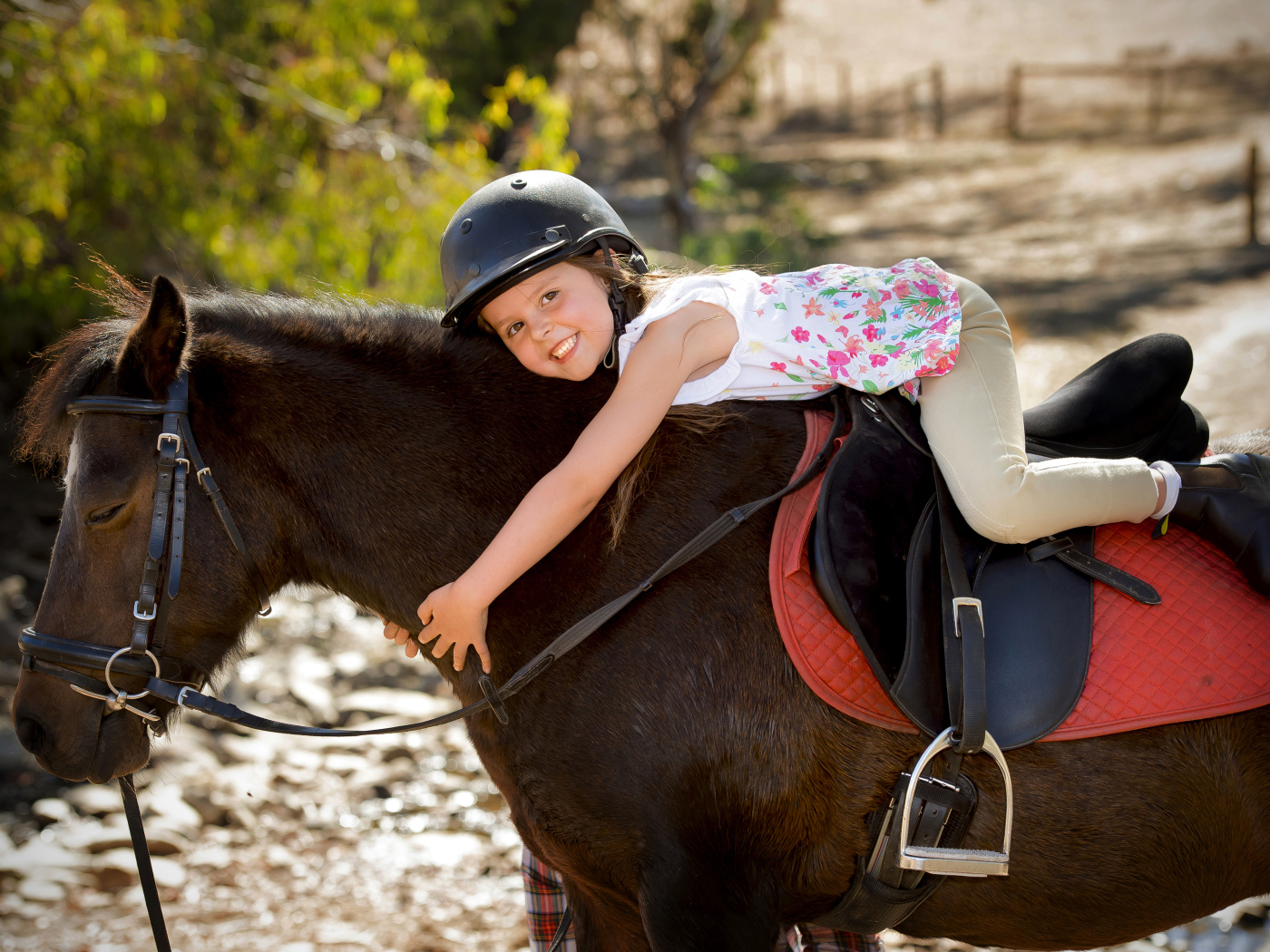Маленькая девочка в шлеме верхом на пони