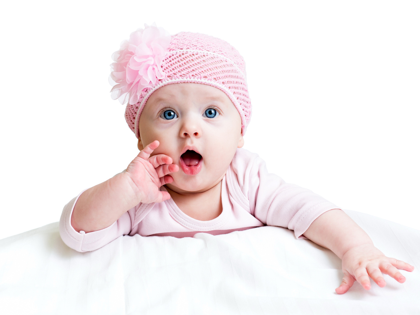 Грудная голубоглазая девочка в розовой шапке на белом фоне