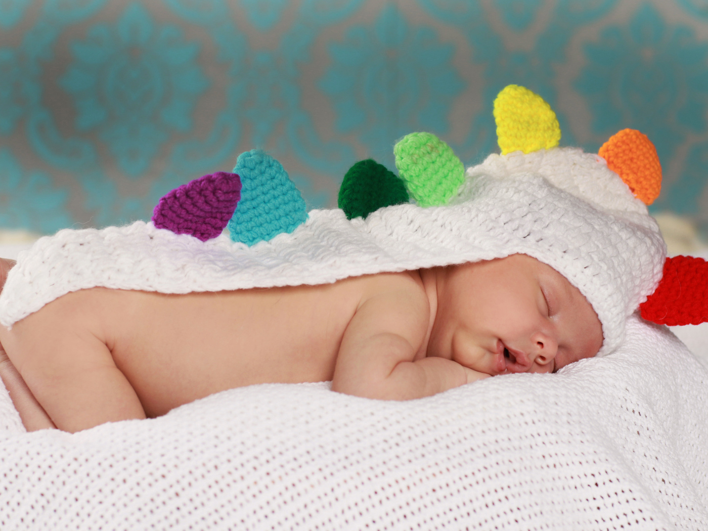 Спящий младенец в белой вязаной накидке