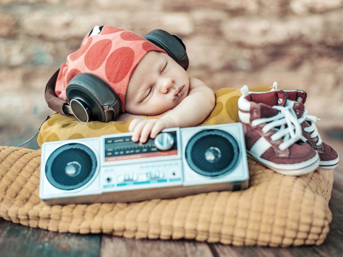 Спящий младенец в наушниках и с игрушечным магнитофоном
