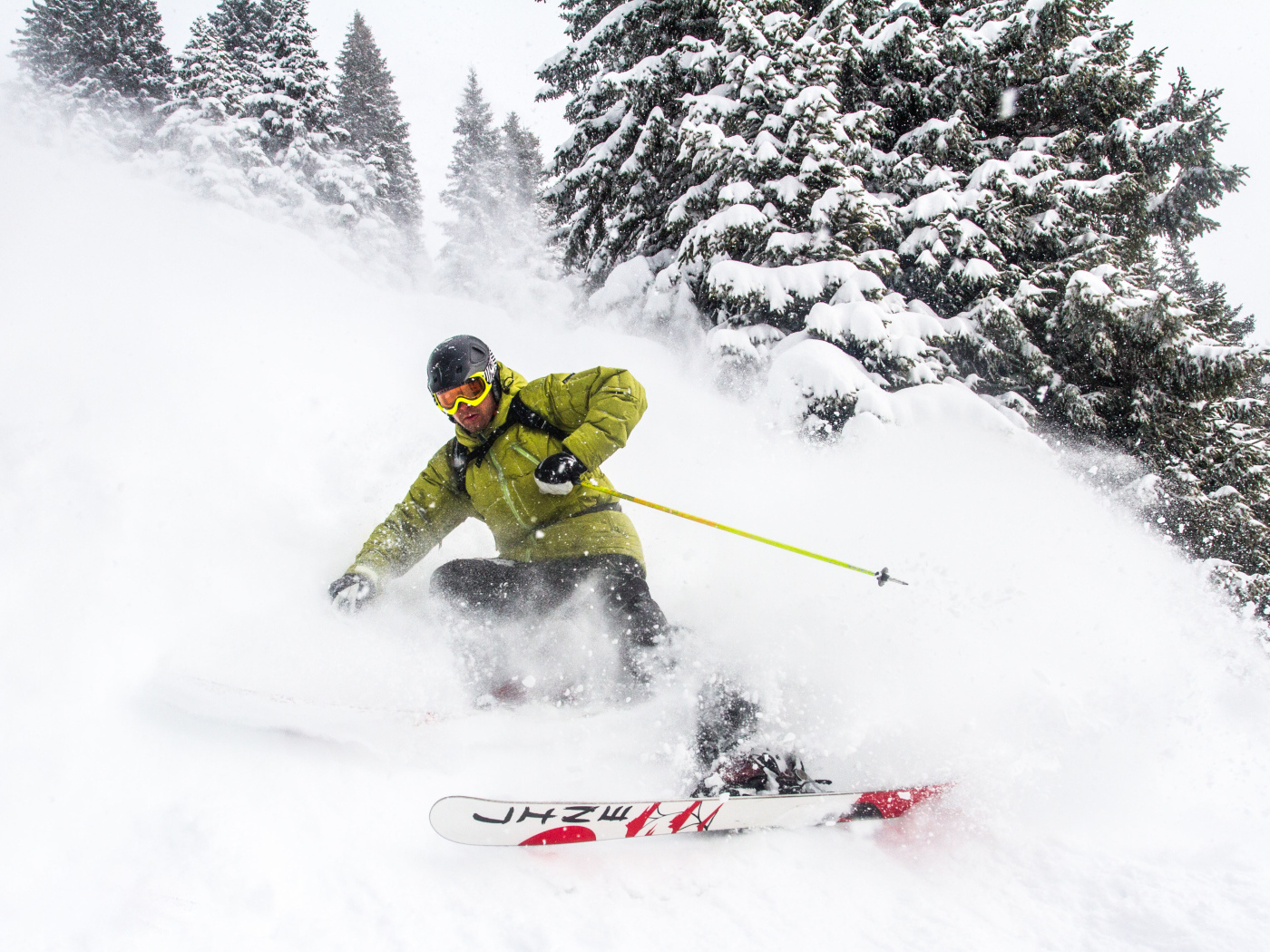 Спортсмен лыжник спускается по заснеженному склону