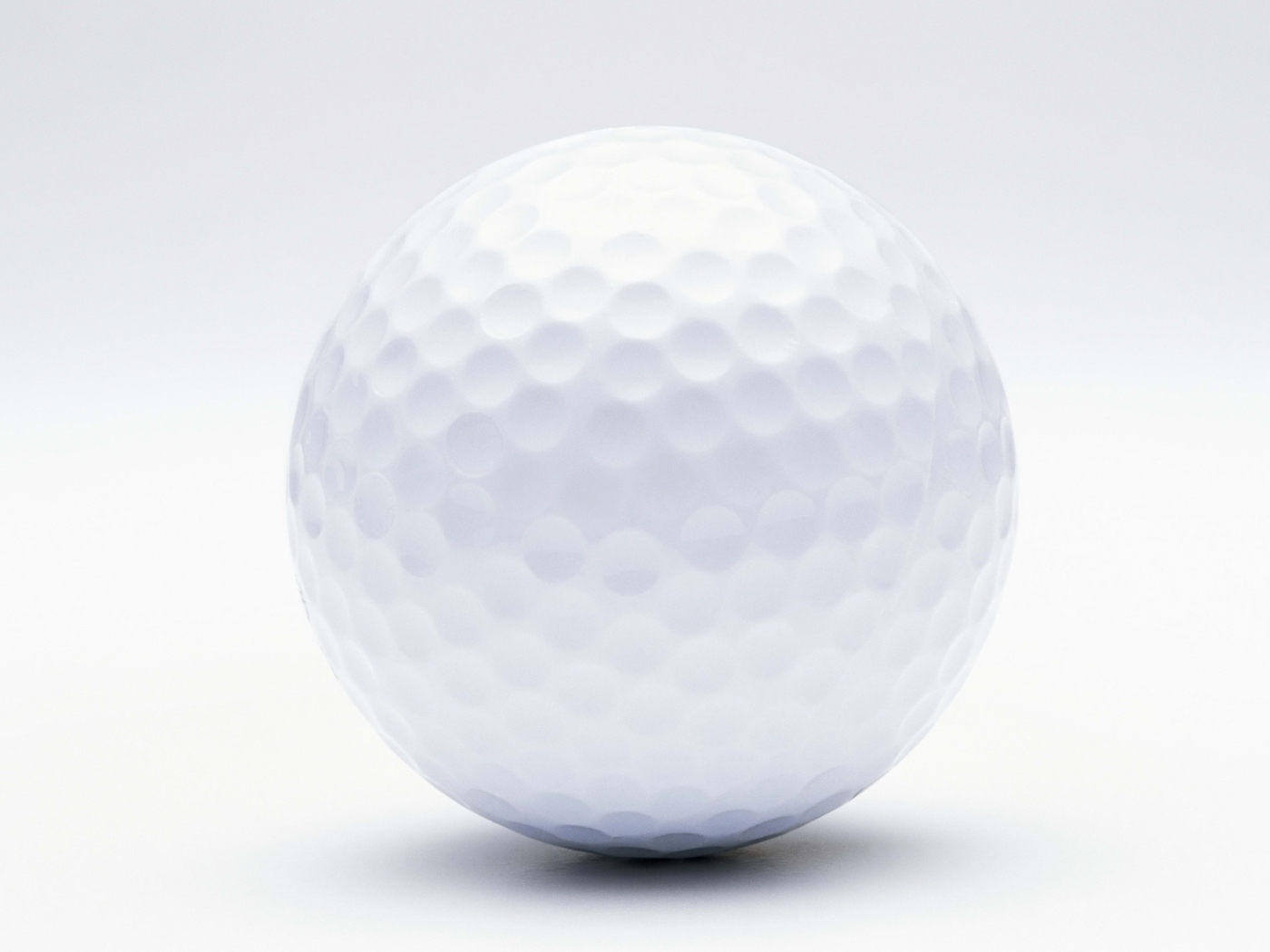 Белый мяч для гольфа на белом фоне крупным планом 