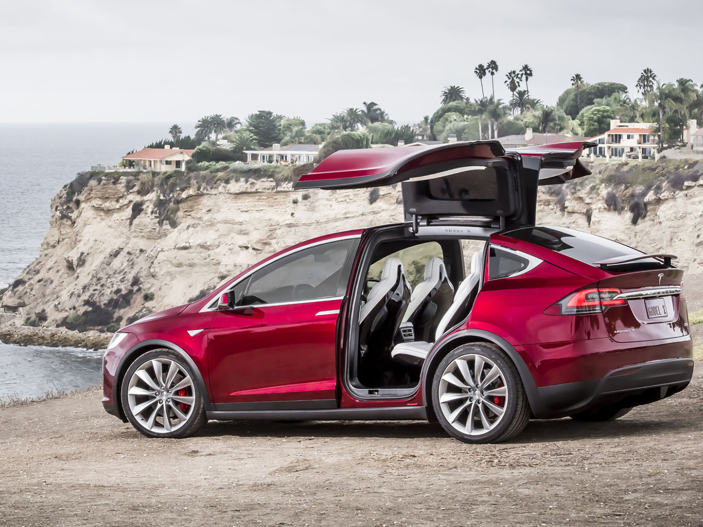Красный электромобиль Тесла на берегу 