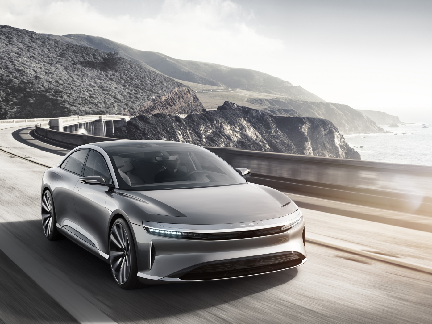 Серебристый электрокар Lucid Air  на трассе