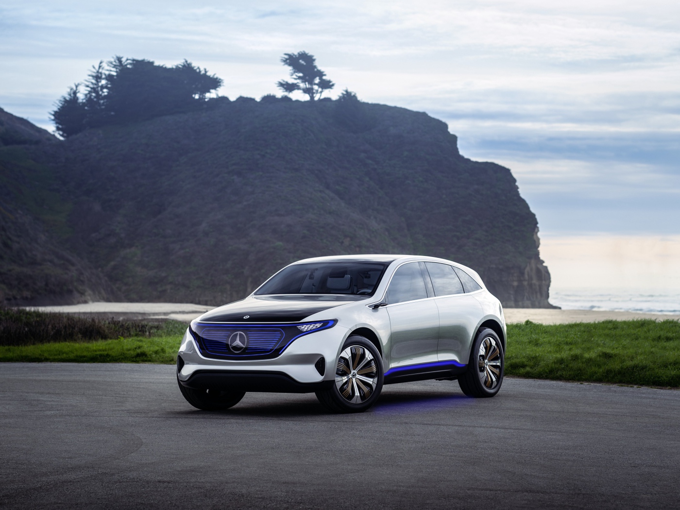 Серебристый электромобиль Mercedes Generation EQ у океана