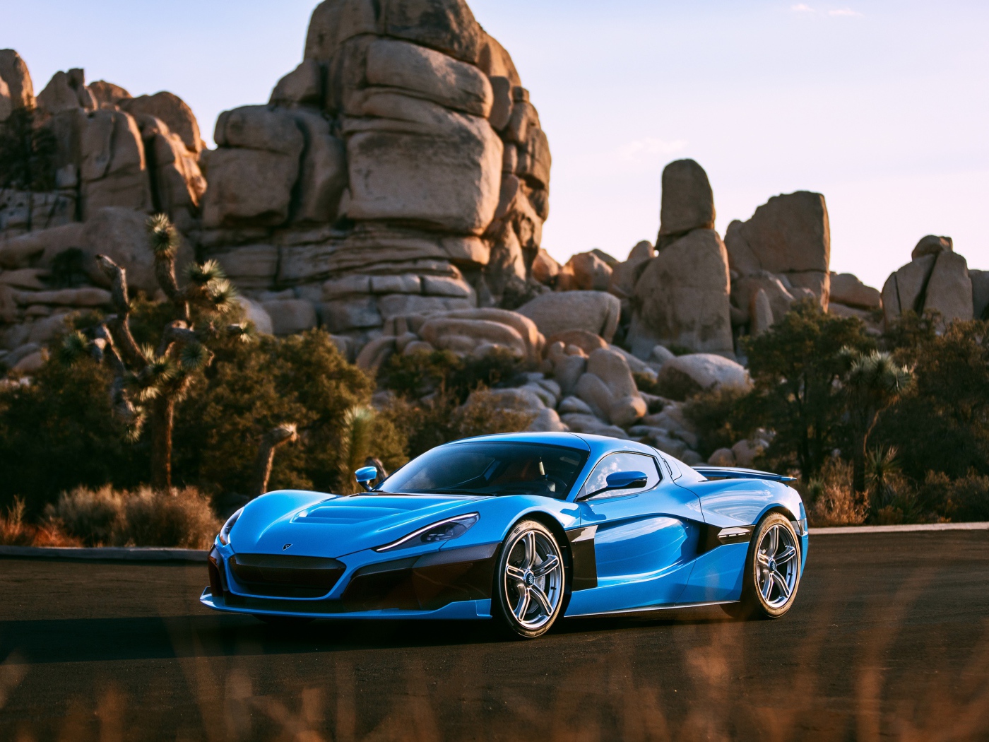 Blue sports car Rimac C_Two against the background of mountains