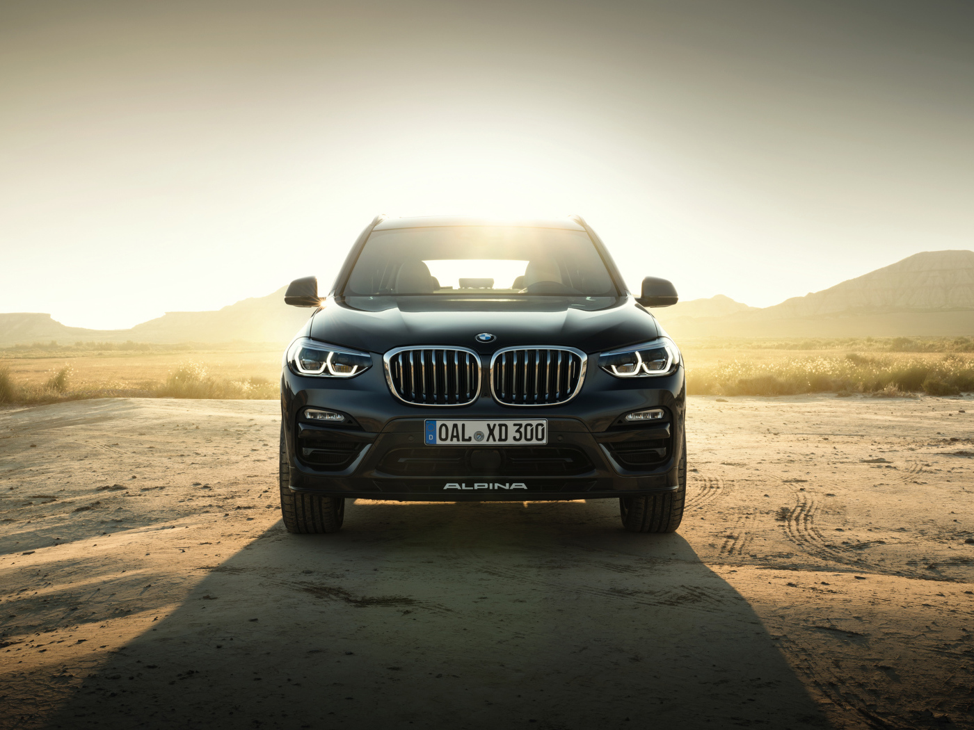 Черный стильный автомобиль BMW Alpina XD3 Allrad, 2018 на фоне солнца
