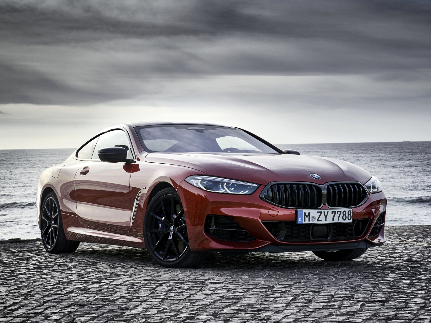 Красный автомобиль BMW 8 Series на фоне моря