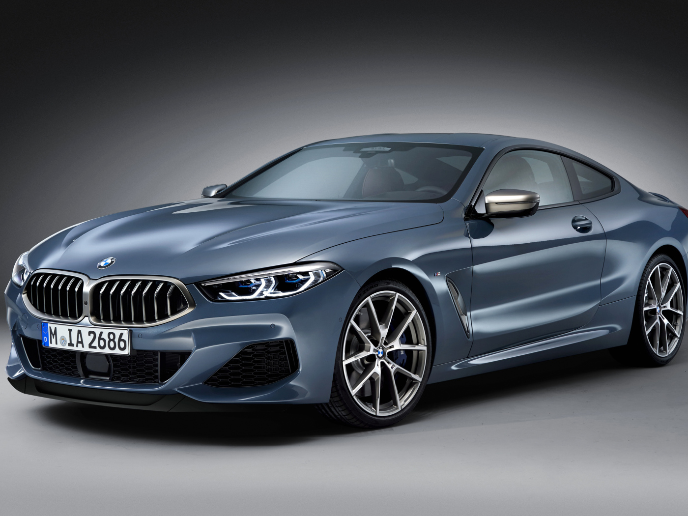 Серебристый автомобиль BMW M850i, 2018 на сером фоне