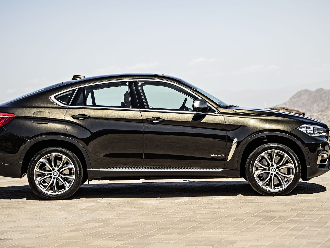 Черный автомобиль BMW X6, 2018 года вид сбоку