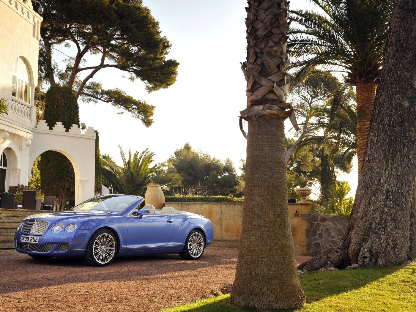 Автомобиль кабриолет Bentley Continental у дорого особняка 