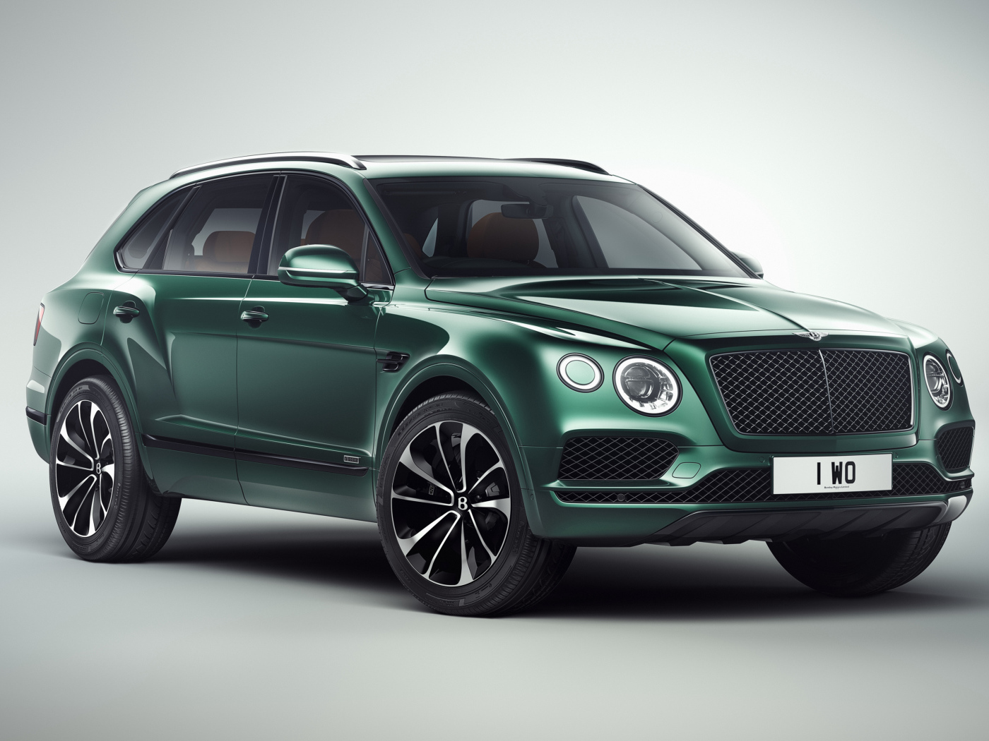 Зеленый автомобиль Bentley Bentayga 2018 года на сером фоне