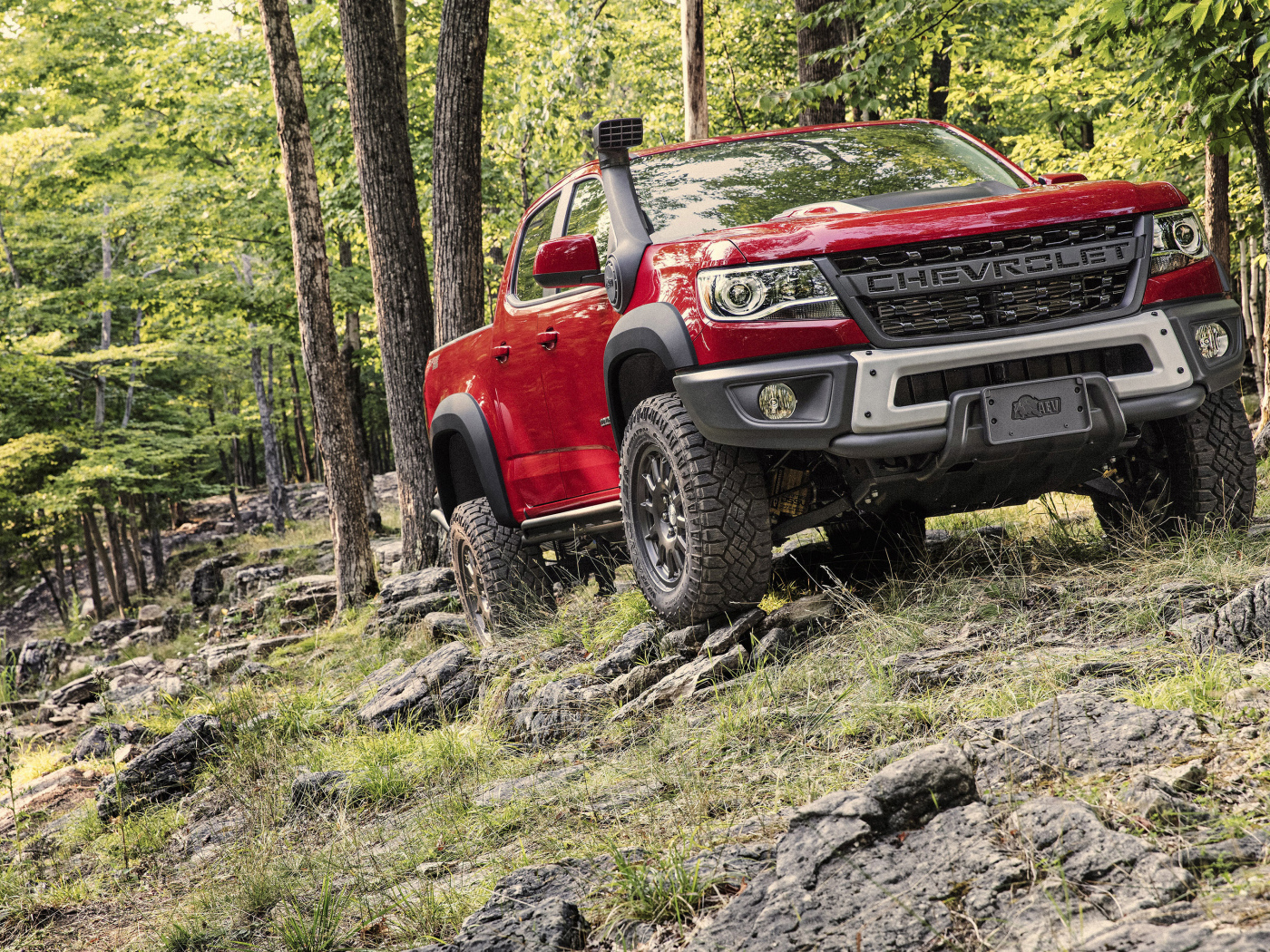 Красный внедорожник Chevrolet Colorado ZR2 Bison, 2019 года в лесу