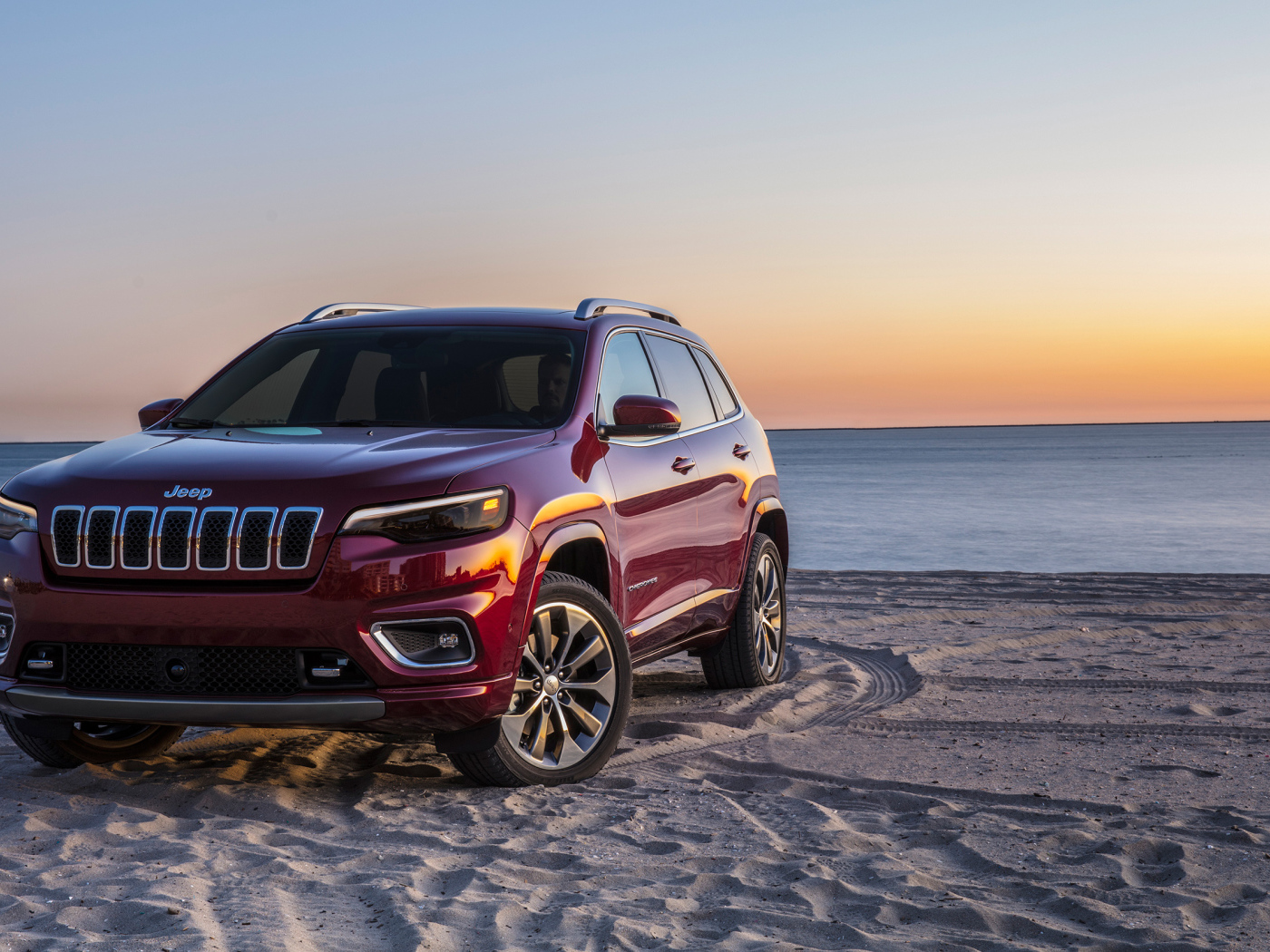 Бордовый внедорожник Jeep Cherokee Overland, 2018 на пляже