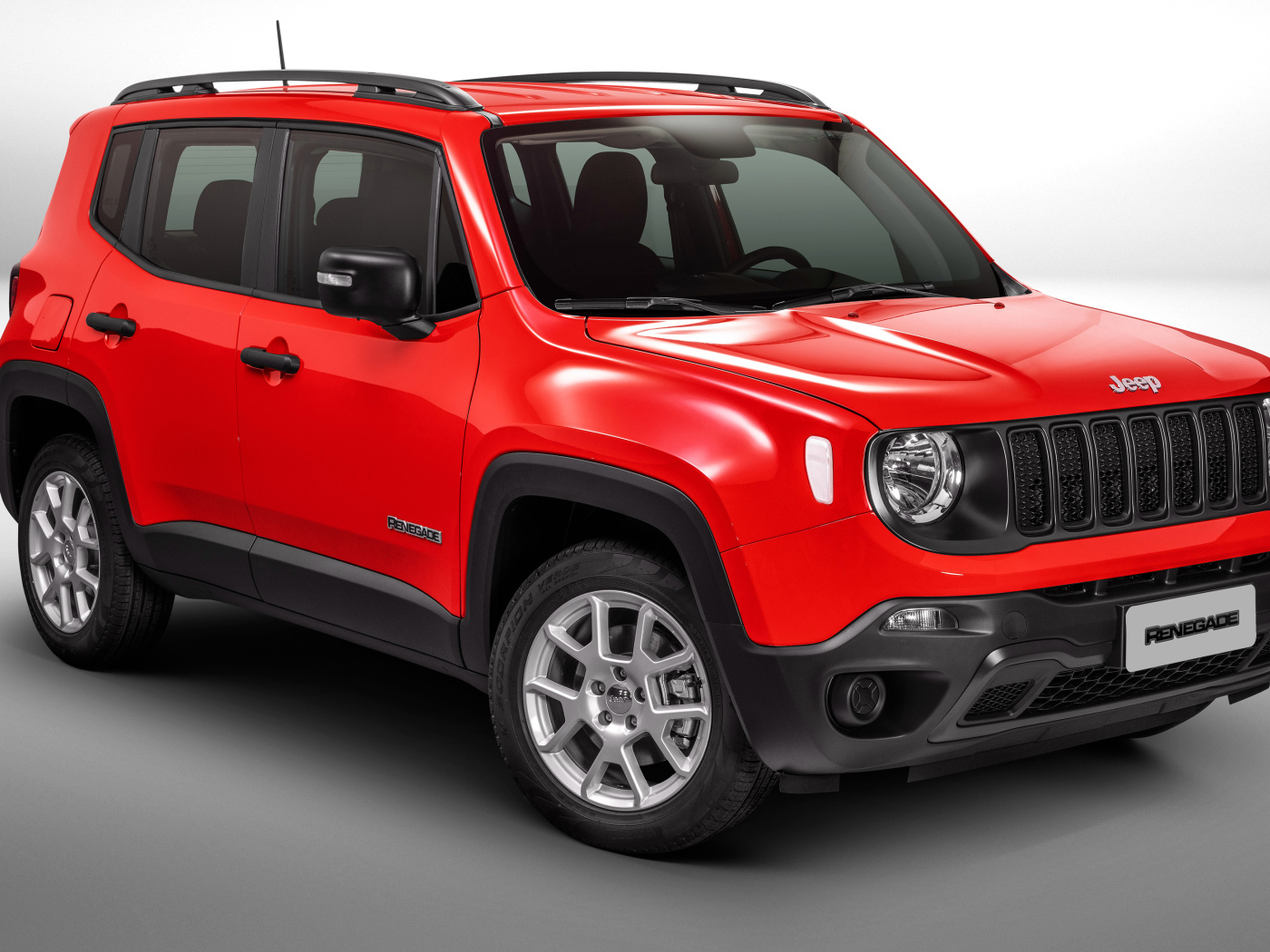 Красный автомобиль Jeep Renegade Sport на сером фоне
