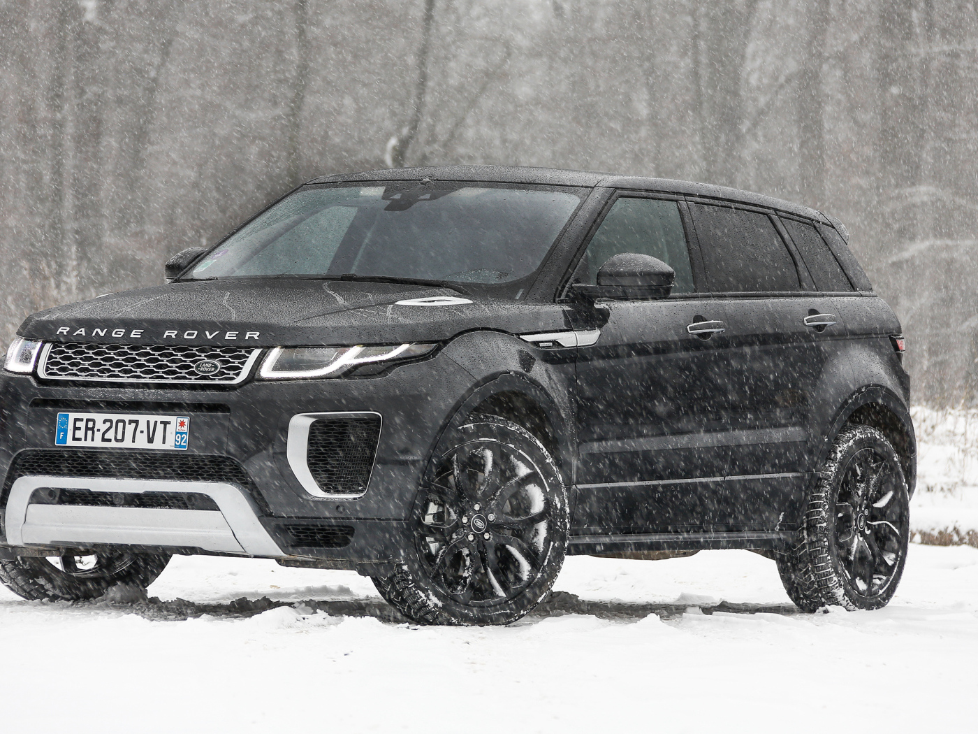 Черный внедорожник Range Rover Evoque Autobiography Si4 на заснеженной дороге