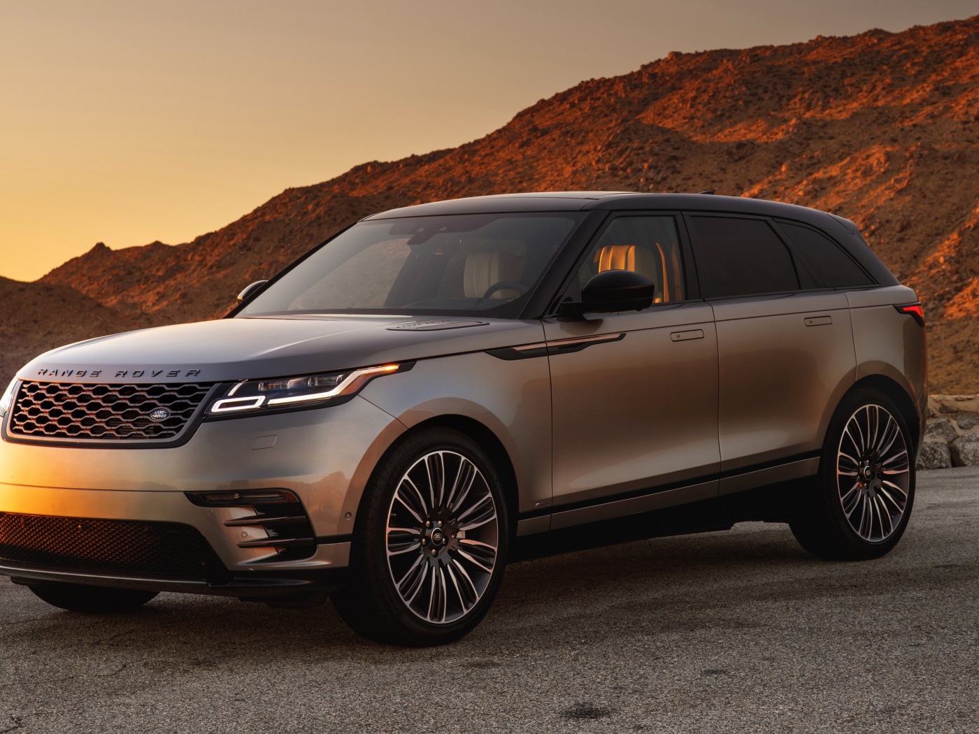 Серебристый внедорожник Land Rover 2018 года на фоне скалы 
