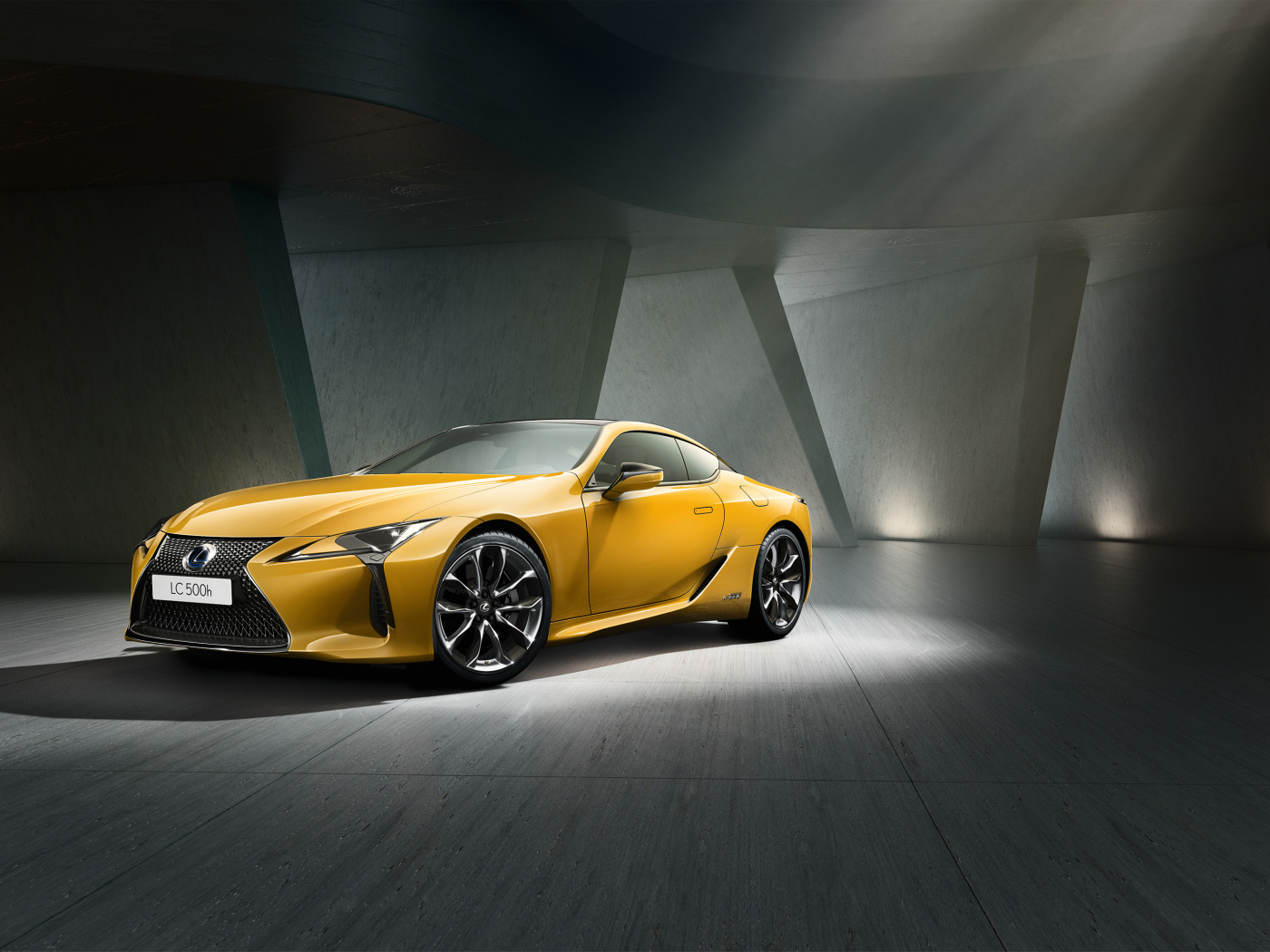 Желтый автомобиль Lexus LC 500 в сером здании