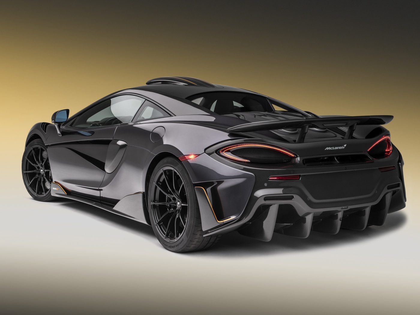 Черный спортивный автомобиль  McLaren 600LT, 2019 года вид сзади