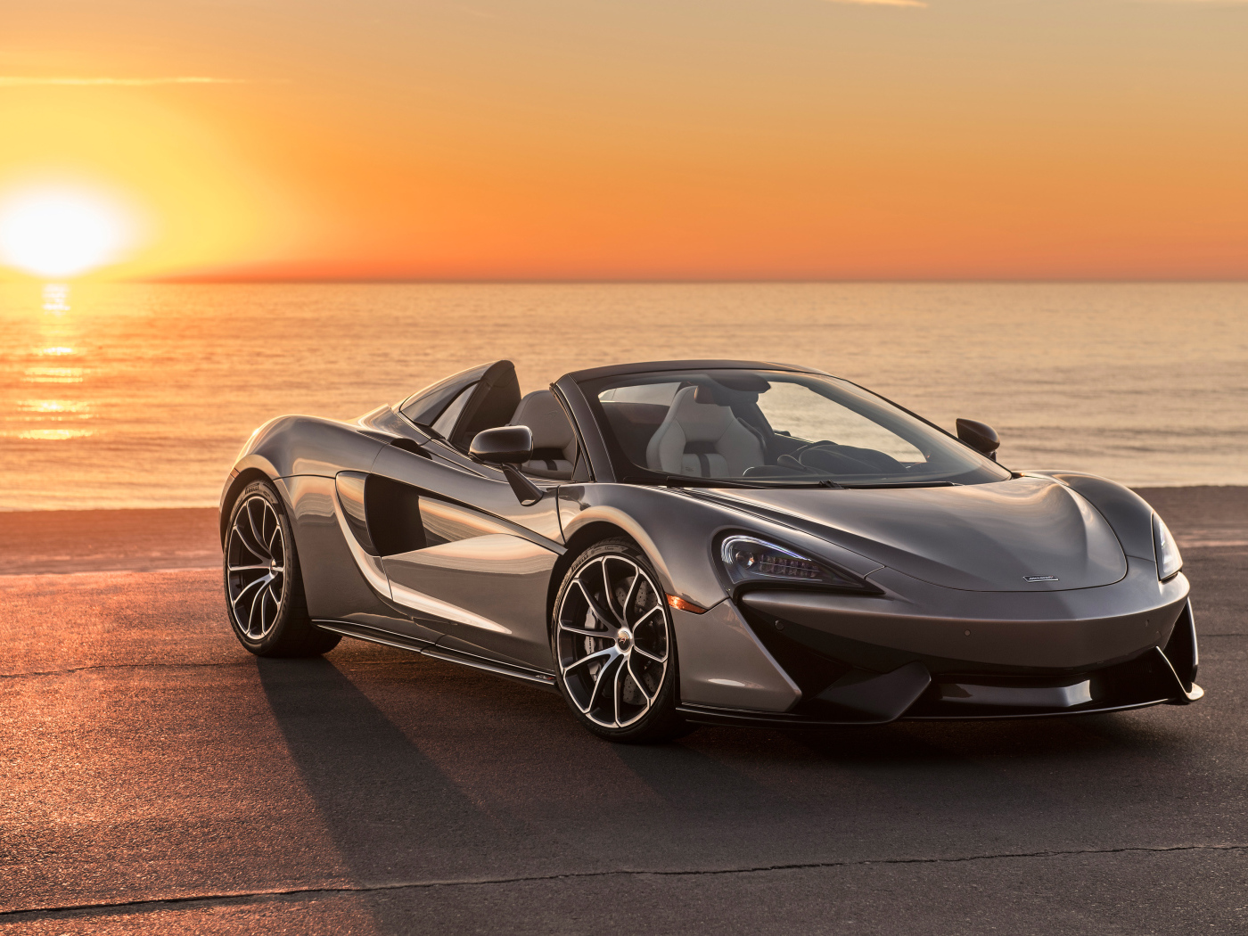 Серебристый  McLaren 570S Spider, 2018 на фоне заката