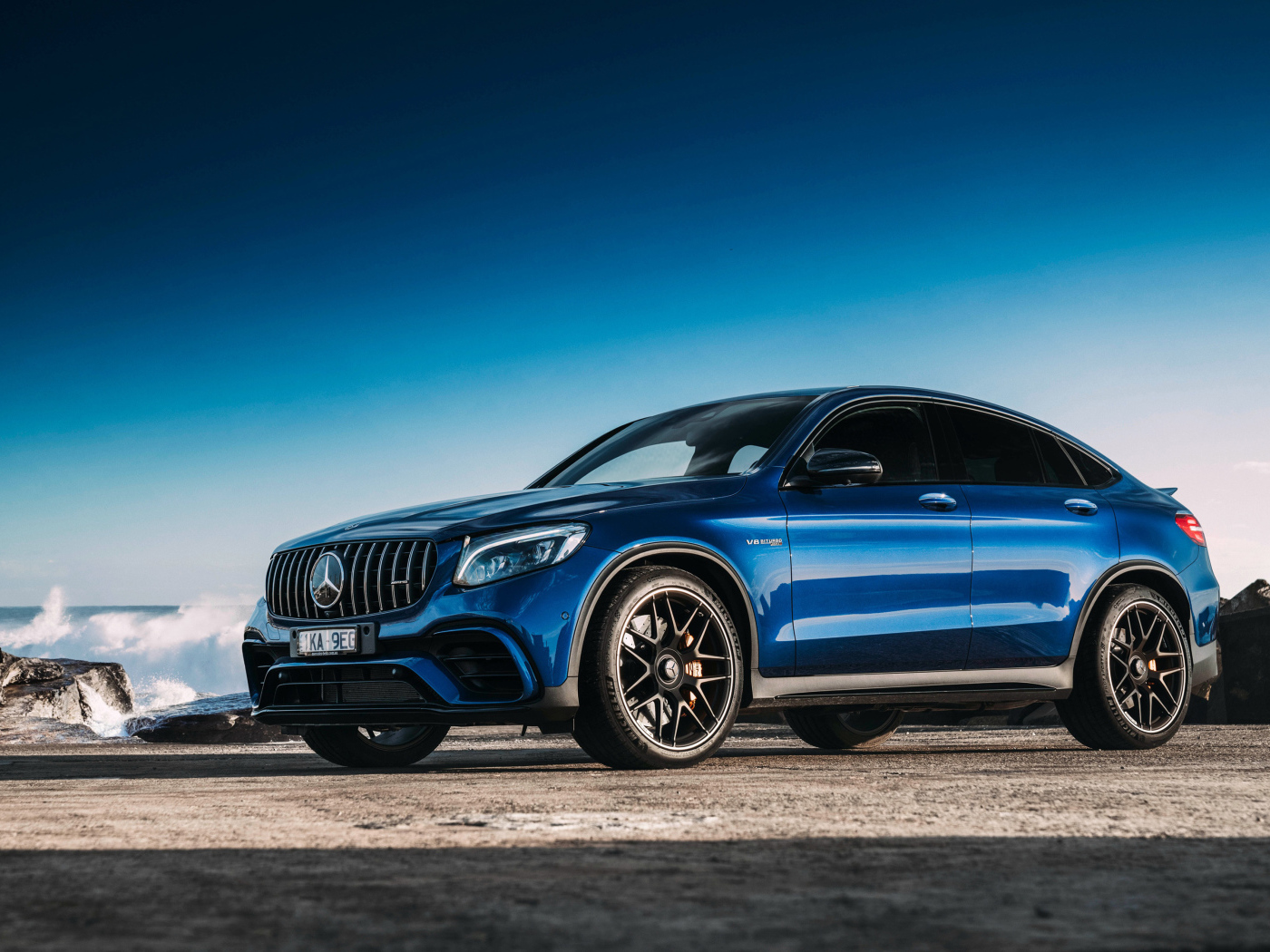 Синий автомобиль Mercedes GLC63 AMG, 2018 года вид сбоку