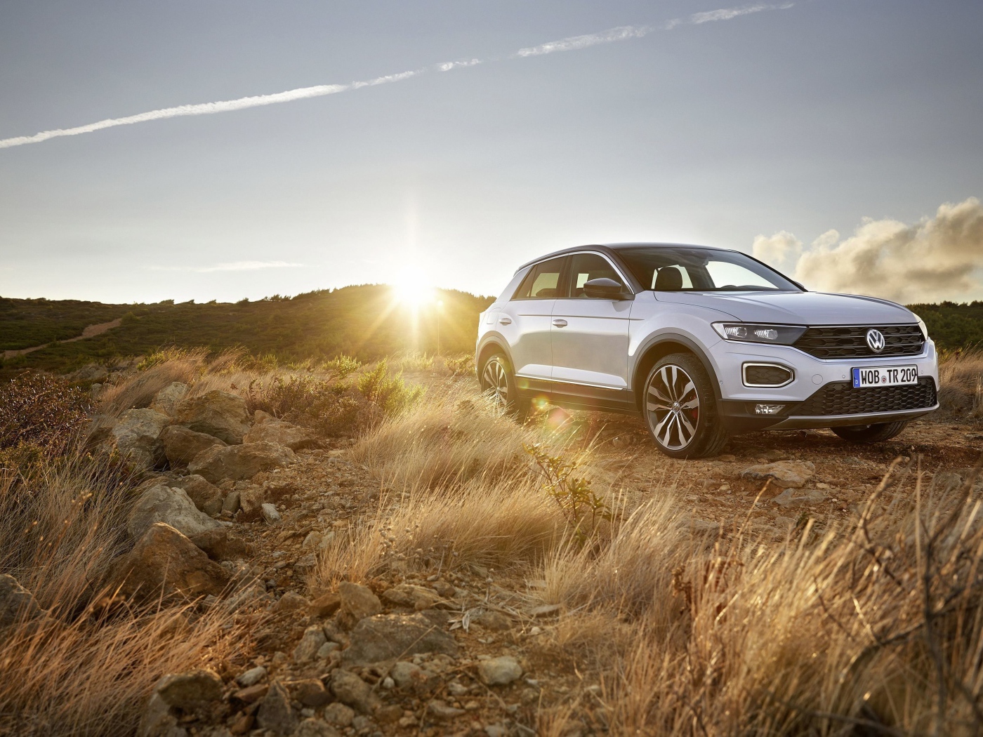 Серебристый внедорожник Volkswagen T-Roc, 2018 года на фоне солнца